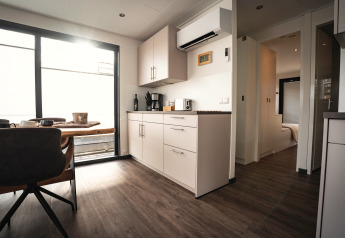 Moderne keuken en eethoek op een woonboot in Höxter met houten vloer en grote ramen voor veel licht.