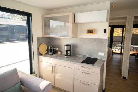 Moderne kitchenette op Houseboat in Höxter met koffiemachine, kookplaat en zonlicht door het raam.