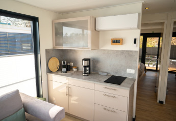 Moderne tekøkken i Houseboat i Höxter med kaffemaskine, induktionskogeplade og solrigt vindue.