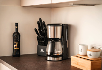 Moderne keuken op een woonboot in Höxter met koffiemachine, messenblok, wijnfles en bewaarpotten.