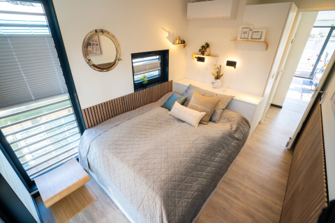 Camera moderna su una houseboat a Höxter, letto matrimoniale, arredamento chiaro e grandi finestre.