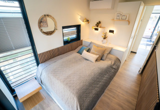 Moderne slaapkamer op woonboot in Höxter, tweepersoonsbed, licht interieur en grote ramen.