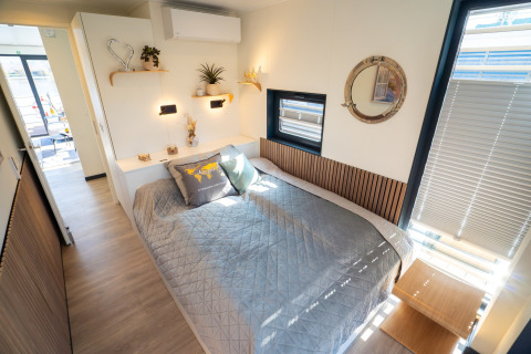 Soveværelse på Houseboat i Höxter med stor seng, spejl, vinduer med persienner og moderne indretning.