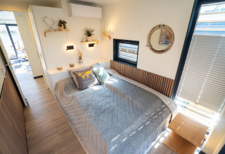 Bedroom on Houseboat in Höxter featuring a large bed, mirror, windows with blinds, and modern decor.