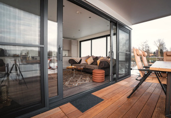 Innen- und Außenbereich eines modernen Hausboots in Höxter, mit Holzterrasse und stilvollem Wohnzimmer.