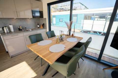 Moderne spise- og køkkenområde på en husbåd i Höxter med store vinduer og elegant interiør.