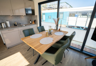 Espace salle à manger et cuisine moderne sur une péniche à Höxter avec grandes baies vitrées.