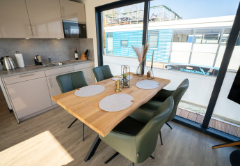 Espace salle à manger et cuisine moderne sur une péniche à Höxter avec grandes baies vitrées.