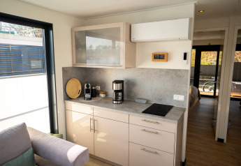 Moderne Pantryküche auf einem Hausboot in Höxter, Deutschland mit Kaffeemaschine und Induktionskochfeld.