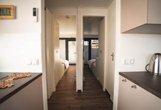 Modern houseboat interior in Höxter, Germany, with two bedrooms, minimalist décor and wooden floor.