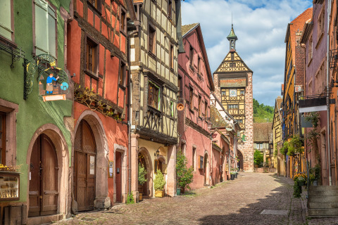 Charmante rue pavée bordée de maisons à colombages colorées près de Corcieux, Grand Est, France.