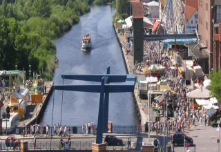 Uitzicht vanaf woonboot Watercamper deluxe op een drukke gracht en een volle straat in Duitsland.