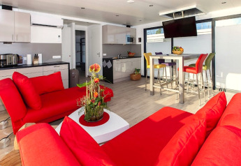 Péniche moderne avec canapés rouges, cuisine lumineuse et chaises colorées, Houseboat Blue Active Allemagne.