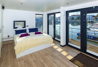 Chambre sur une péniche avec grandes fenêtres et vue sur le port à Ribnitz-Damgarten, Allemagne.