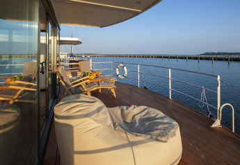 Gemütliche Terrasse eines Hausboots mit Liegestühlen und Blick aufs Wasser, Floating Houses Blue Active, Deutschland