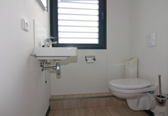 Modernes Badezimmer auf einem Hausboot mit Wandtoilette, Waschbecken und Fenster in Ribnitz-Damgarten.