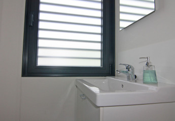 Modernes Badezimmer auf einem Hausboot mit rechteckigem Waschbecken, Wasserhahn und Seifenspender.