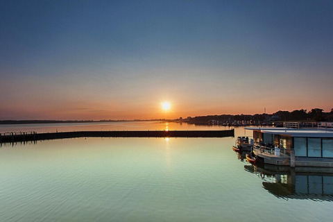 Solnedgang over vandet ved Houseboat ‘Floating Houses Blue Active, Ribnitz-Damgarten’ i Tyskland.