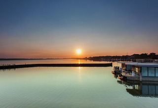 Coucher de soleil sur l’eau près de la péniche ‘Floating Houses Blue Active, Ribnitz-Damgarten’ en Allemagne.