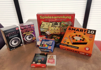Jeux de société comme Smart 10, Hitster et Spielesammlung sur une table de péniche en Allemagne.
