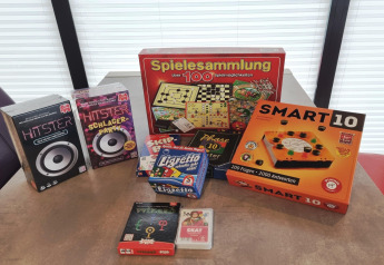Brett- und Kartenspiele wie Smart 10 und Spielesammlung auf einem Tisch in einem Hausboot in Deutschland.