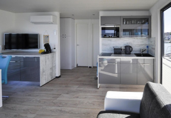 Salon et cuisine modernes sur la péniche Floating House « Leni » à Ribnitz-Damgarten, Allemagne, avec vue.