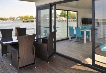 Modernes Esszimmer und Terrasse auf einem Hausboot mit Blick aufs Wasser in Deutschland.