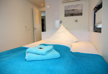 Bedroom inside Houseboat 'Floating House Leni', Ribnitz-Damgarten, Germany with blue towels on bed.