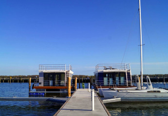 Hausboot 'Floating House Luisa' im Hafen von Ribnitz-Damgarten, Deutschland, bei klarem Himmel.