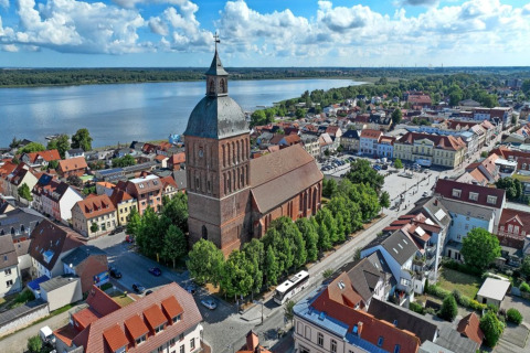 Luftfoto af Ribnitz-Damgarten med kirke, huse og sø, set fra husbåd 'Luisa' i Tyskland.