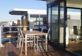 Hausboot 'Luisa' in Ribnitz-Damgarten mit moderner Terrasse und Sitzbereich am Wasser, Deutschland.