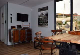 Interieur van het huisboot «Leni» in Duitsland met houten meubels en zicht op de jachthaven.