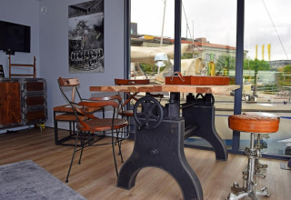 Zona giorno in stile industriale sulla houseboat Leni in Germania, con ampie vetrate e arredi unici.