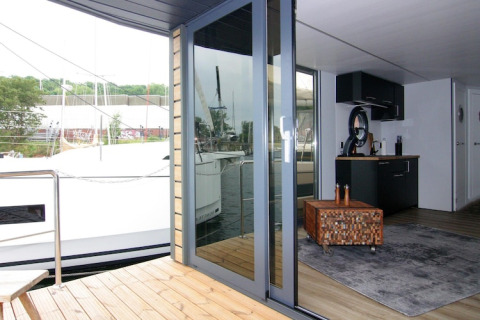 Vista dal ponte verso il soggiorno della houseboat «Leni» in Germania con marina sullo sfondo.