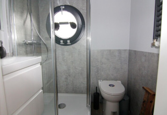Salle de bain moderne sur péniche avec fenêtre ronde, douche, toilettes et meuble, Houseboat «Leni», Allemagne.