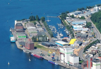 Vue aérienne d'une marina en Allemagne avec une péniche, des bateaux, des bâtiments industriels et entrepôts.