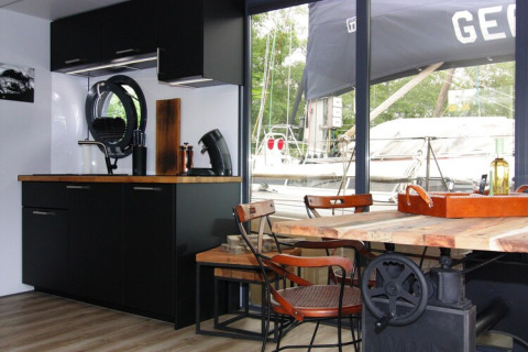 Modern kitchen and dining area with view of boats, taken on Houseboat «Lina» in Germany.