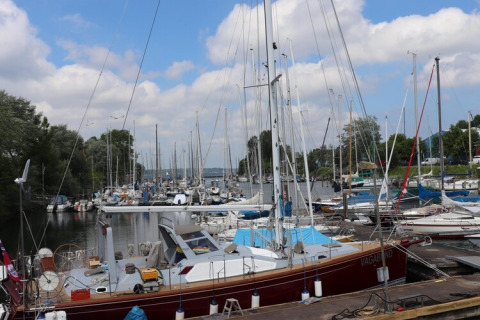 Photo of sailboats moored at a marina, including the 'VAGABOND', under a partly cloudy sky in Germany.