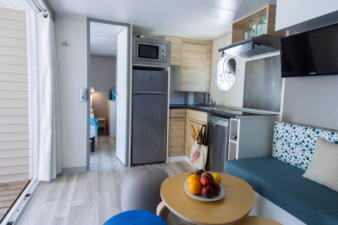 Cuisine moderne et coin salon dans une lodge Tamarit Park Resort 2 PATIO en Espagne, ambiance lumineuse.