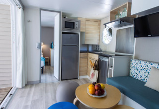 Cuisine moderne et coin salon dans une lodge Tamarit Park Resort 2 PATIO en Espagne, ambiance lumineuse.