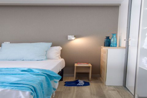 Chambre moderne au Tamarit Park Resort 2 PATIO en Espagne, avec des touches de bleu clair et mobilier minimaliste.