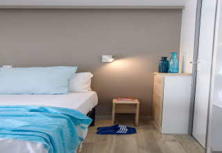 Chambre moderne au Tamarit Park Resort 2 PATIO en Espagne, avec des touches de bleu clair et mobilier minimaliste.