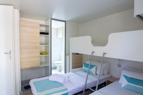 Chambre au Tamarit Park Resort 2 PATIO en Espagne avec lits superposés, lits simples et déco moderne.