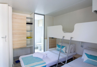 Chambre au Tamarit Park Resort 2 PATIO en Espagne avec lits superposés, lits simples et déco moderne.
