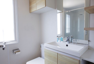 Salle de bain moderne au Tamarit Park Resort 2 PATIO en Espagne avec lavabo, miroir, toilettes et fenêtre.