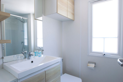 Salle de bain moderne et lumineuse avec douche, lavabo et grande fenêtre au Tamarit Park Resort 2 PATIO en Espagne.