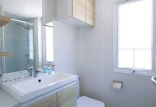 Salle de bain moderne et lumineuse avec douche, lavabo et grande fenêtre au Tamarit Park Resort 2 PATIO en Espagne.
