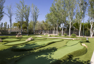 Parcours de mini-golf entouré d’arbres dans un cadre verdoyant au Tamarit Park Resort 2 PATIO en Espagne.
