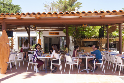 Terrasse du Tamarit Park Resort 2 PATIO en Espagne, clients assis sous un auvent en bois profitant du repas.