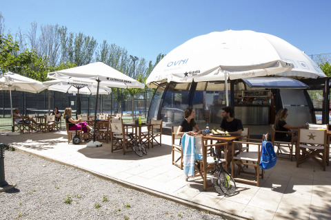 Espace café en plein air au Tamarit Park Resort 2 PATIO en Espagne, avec clients assis sous des parasols.